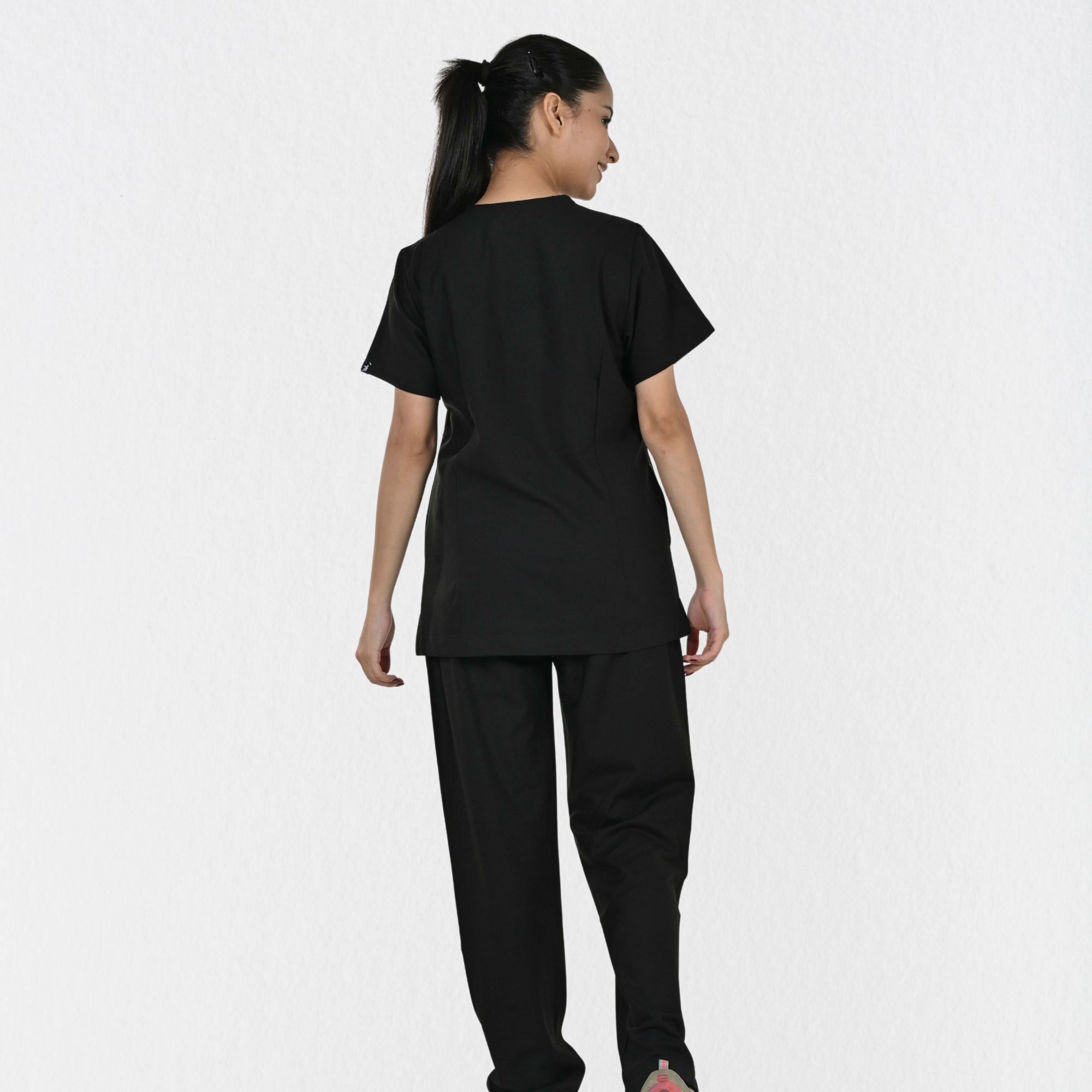 Women's black 4-way stretch scrub set side view — tailored fit for female doctors physiotherapists, independent sizing black clinical workwear India

