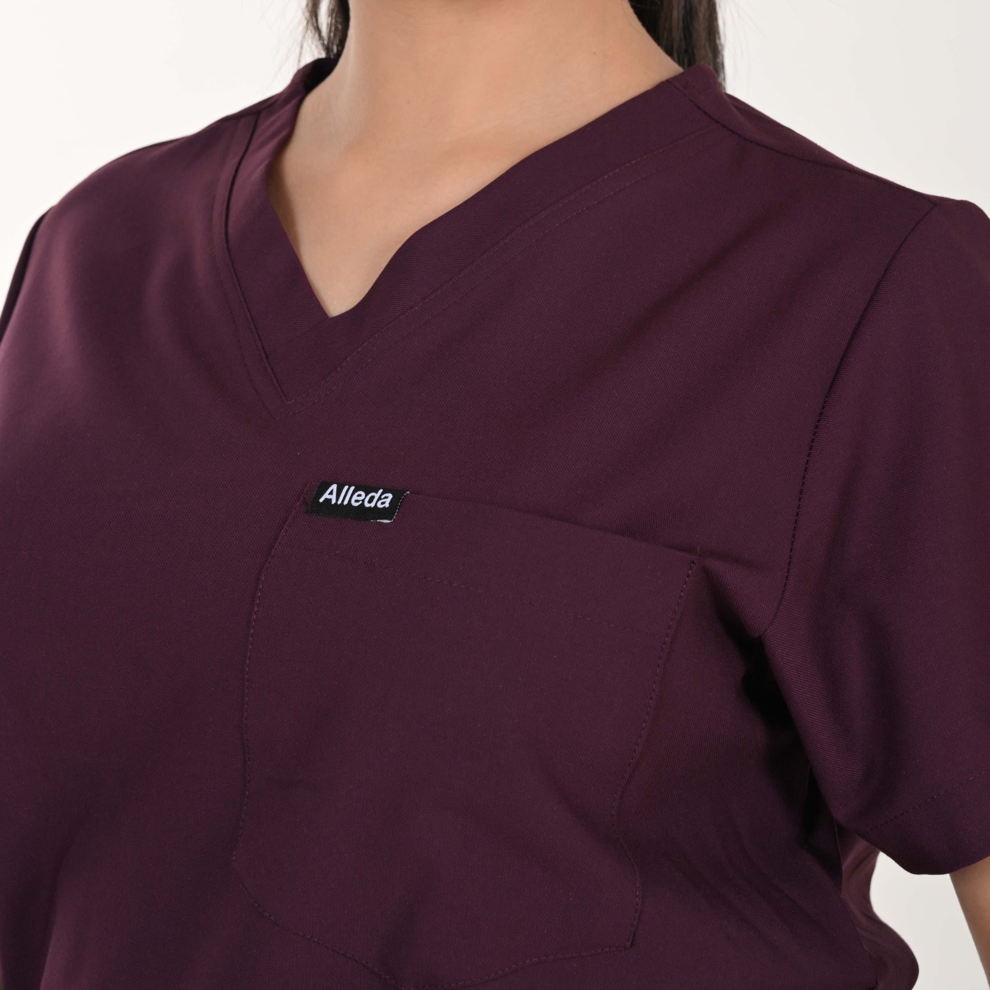 Female doctor specialist wearing Alleda UltraFlex wine women's medical scrub set — best maroon burgundy women's hospital workwear independent sizing India
